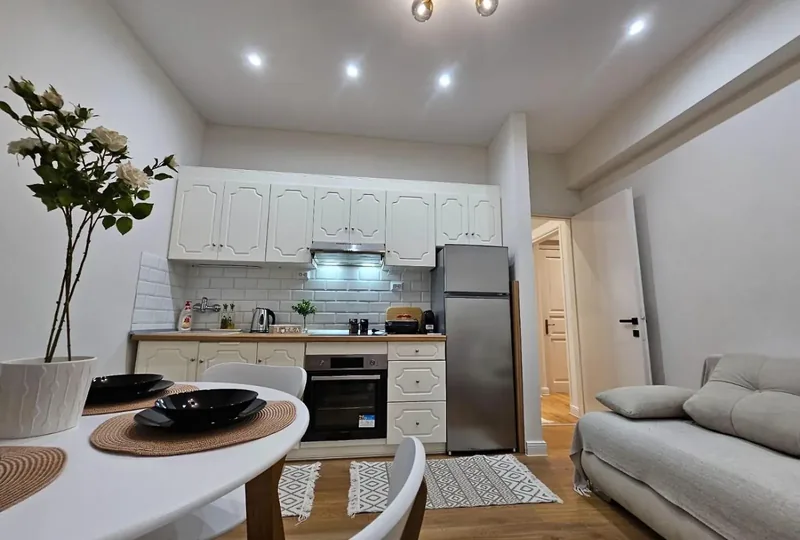 Open-plan living area with white kitchen and sofa at Eda House